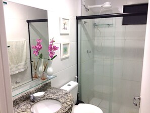 Chuveiro, secador de cabelo, toalhas de banho, papel higiênico