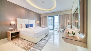 A modern hotel room with a large bed, bedside tables, a mirror, and a view of the city. - Sophisticated 2BR at DAMAC Towers by Paramount A Business Bay by Deluxe Holiday Homes (Dubai)