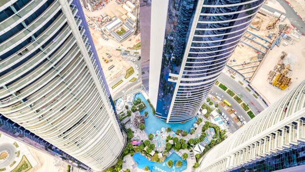 A high-rise building with a curved facade, a central courtyard with a water feature, and a surrounding urban environment. - Sophisticated 2BR at DAMAC Towers by Paramount A Business Bay by Deluxe Holiday Homes (Dubai)
