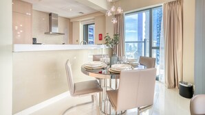 A modern dining area with a round table, chairs, and a view of the city through large windows. - Sophisticated 2BR at DAMAC Towers by Paramount A Business Bay by Deluxe Holiday Homes (Dubai)