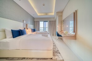 Une chambre d’hôtel moderne avec un grand lit, un bureau et une vue sur la ville.