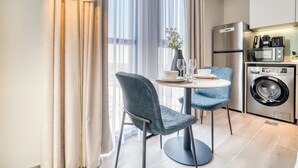 Una cocina moderna con lavadora, refrigerador y comedor con mesa y sillas.