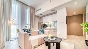 Un apartamento moderno con sofá, mesa de comedor y zona de cocina.