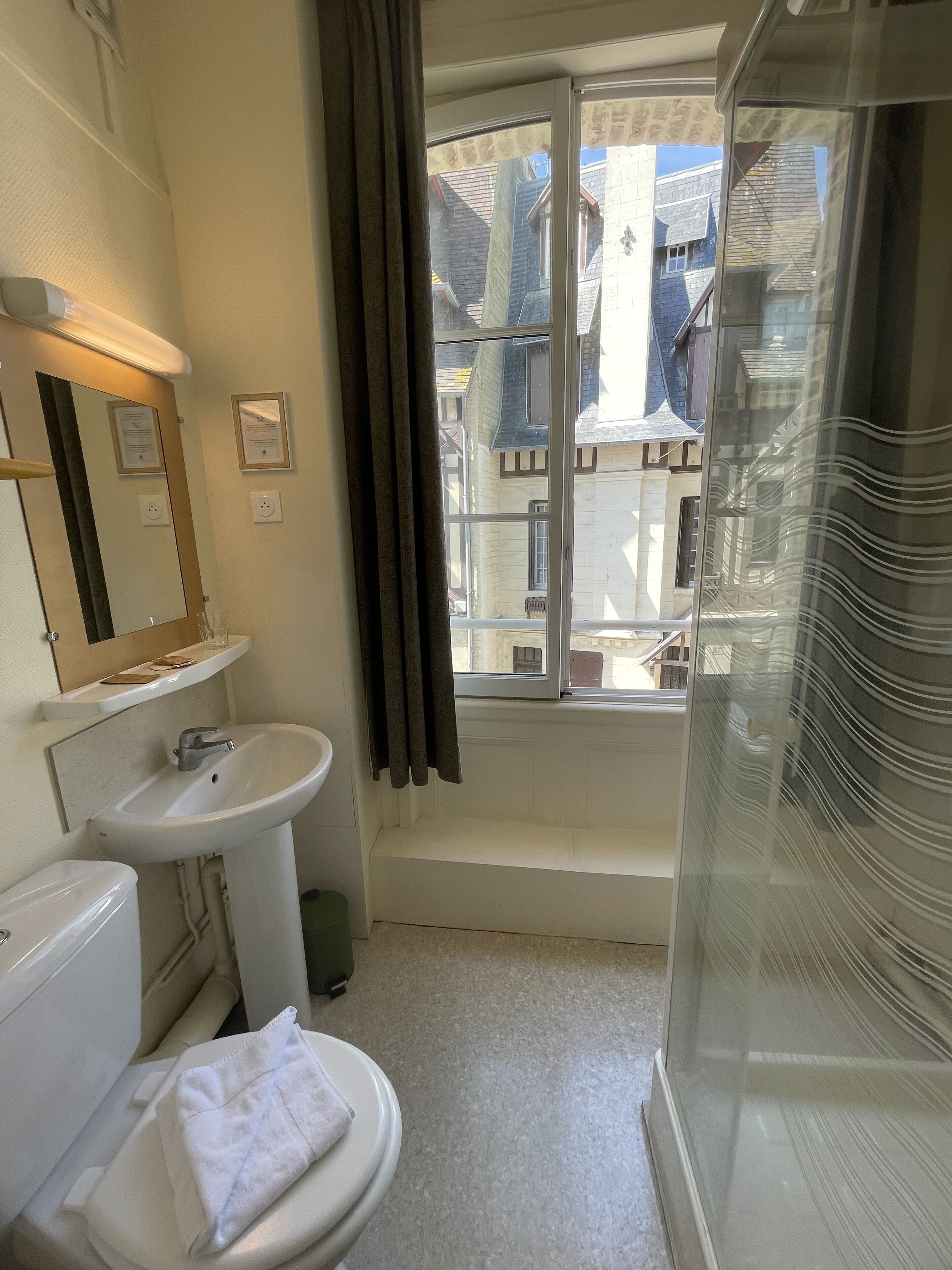 A bathroom with a toilet, sink, and shower.