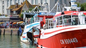 Un bateau rouge et blanc était amarré dans une marina, et on pouvait apercevoir en arrière-plan un bâtiment sur lequel était inscrit le mot « CASINO ».