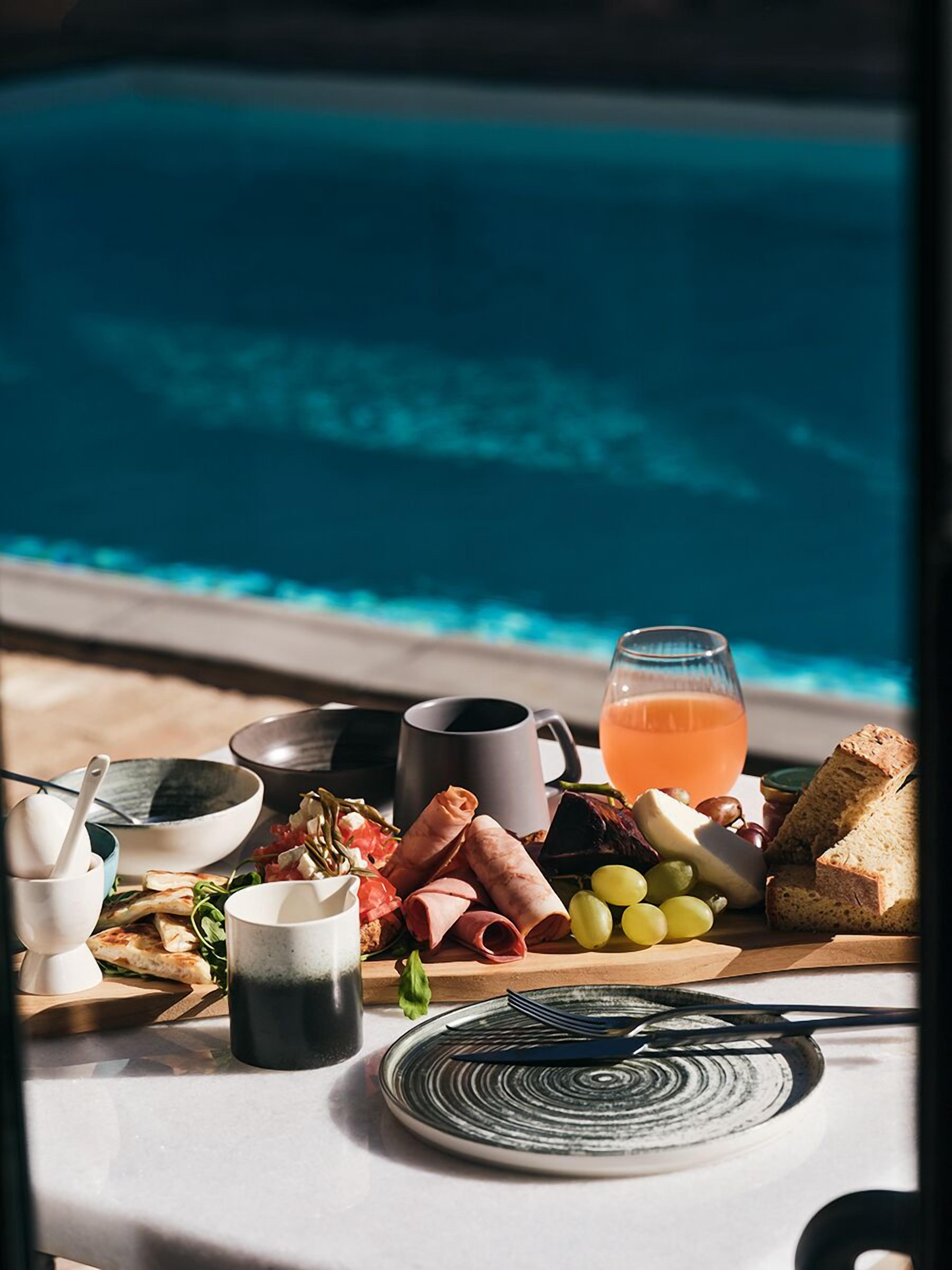 A breakfast setting with a view of a swimming pool.