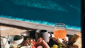 A breakfast setting with a view of a swimming pool.