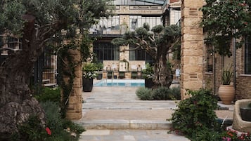 A courtyard with a pool, stone pathway, and a building with a sign reading "No Ordinary Things".