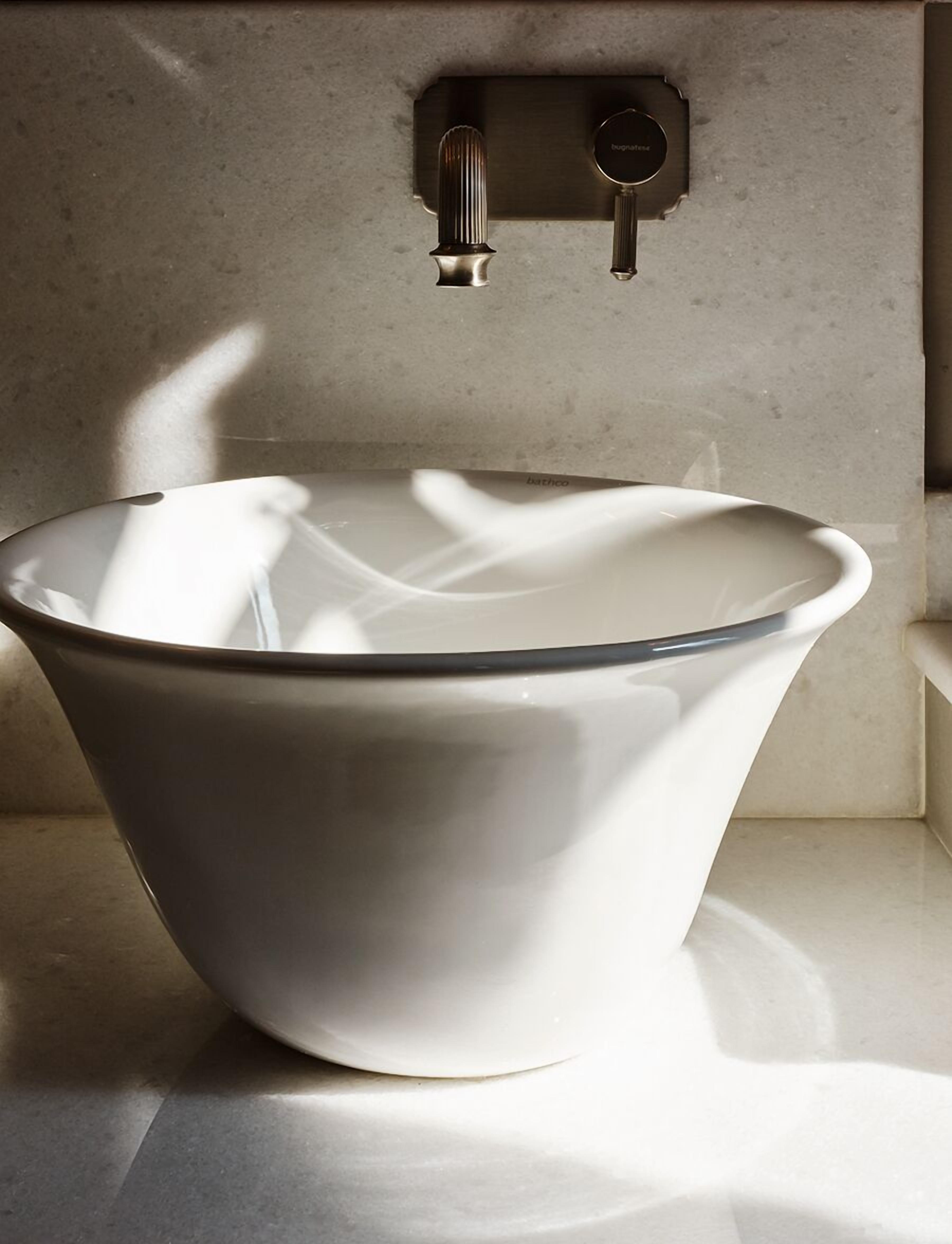 Une salle de bain moderne avec un lavabo en céramique blanche et un robinet mural.
