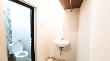 A small bathroom with a toilet, sink, and tiled floor.