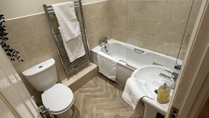 A modern bathroom with a toilet, bathtub, and shower. - Charming 2-bed Apartment in Danbury, Essex (Chelmsford)