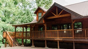 Un chalet en bois doté d’un balcon et d’un escalier menant à l’étage supérieur.
