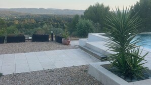 A rooftop terrace with a pool, gravel, and a view of distant hills. - Beautiful new housse with splendid view and big pool. (Cotignac)