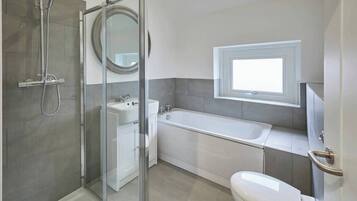 Bathtub, hair dryer, towels, shampoo