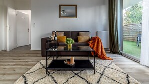 Ein modernes Wohnzimmer mit Sofa, Couchtisch und Blick ins Freie.