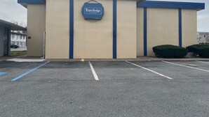 Un hôtel Travelodge à la façade beige et aux touches de couleur bleue.