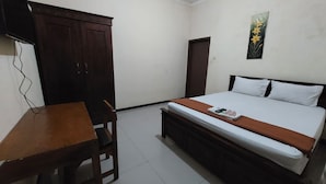 A bedroom with a bed, a desk, and a wardrobe. - Kaja Guest House by Pesen Kamar (Malang)