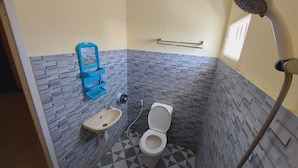 A bathroom with a toilet, sink, and shower. - Kaja Guest House by Pesen Kamar (Malang)
