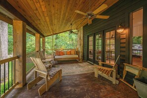 A wooden porch with a ceiling fan, a bench, and a sofa with cushions. - Charming Dog Friendly Cottage w/ Modern Touches (Oakland)
