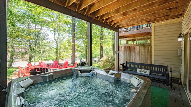 A hot tub area with wooden beams, red chairs, and a bench. - Cozy Deep Creek Cabin w/ Hot Tub & Fireplace (Oakland)