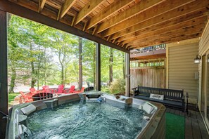 A hot tub area with wooden beams, red chairs, and a bench. - Cozy Deep Creek Cabin w/ Hot Tub & Fireplace (Oakland)