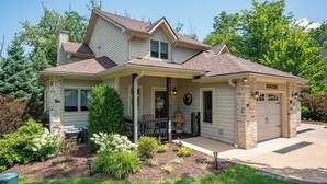 A two-story house with a front porch, a garage, and a well-maintained garden. - Cozy Deep Creek Cabin w/ Hot Tub & Fireplace (Oakland)