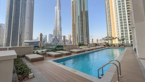 A rooftop pool with lounge seating and a view of tall buildings. - Luxury 2Bedroom w/ Burj Khalifa & Fountain Views (Dubai)