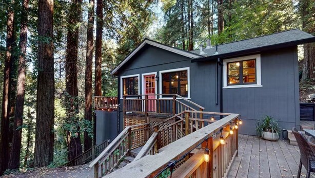 A cabin with a deck, surrounded by tall trees. - Stairway to Haven ~ Family Cabin in Monte Rio (Monte Rio)