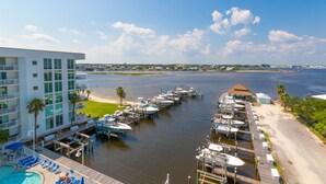 A marina with boats docked, a pool area, and a building with multiple floors. - The Pass 608 by Liquid Life (Orange Beach)