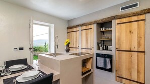 Una cocina compacta con una isla central, armarios de madera y horno integrado.