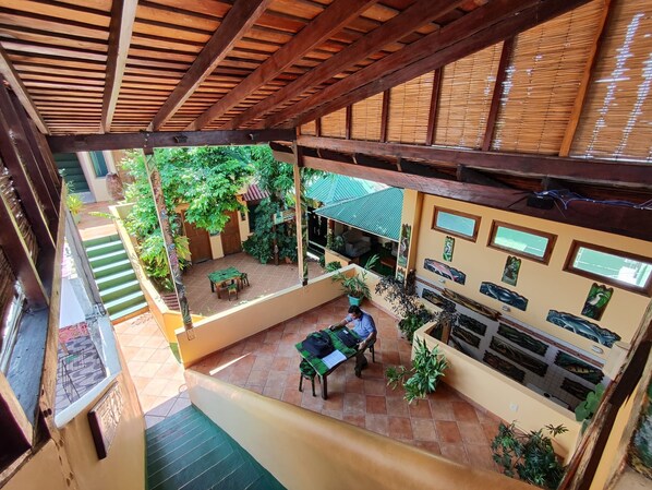 An indoor-outdoor space with a wooden ceiling, tiled floor, and a dining area with a table and chairs. - Hostel Manaus (Manaus)