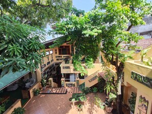 A courtyard with a tiled floor, potted plants, and a staircase leading to an upper level. - Hostel Manaus (Manaus)
