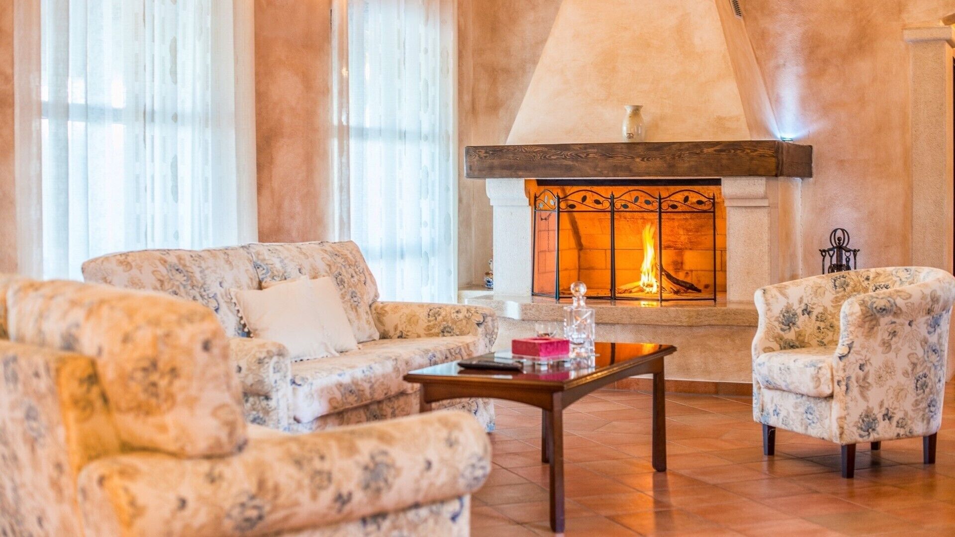 A living room with a fireplace, patterned sofas, and a coffee table.