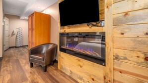 A wooden-paneled room with a flat-screen TV, a glass-fronted aquarium, and a leather chair. - Solitude Bear Room Ada 103 - Estes Park 1 Bedroom Studio by RedAwning (Estes Park)