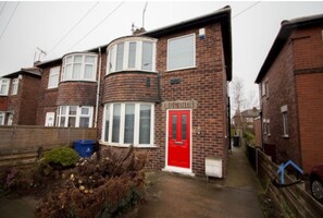 Traditional British-style home with a brick facade, bay window, and garden.