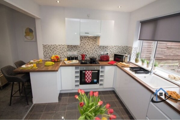 Enjoy cooking in this kitchen with a central island, oven, and microwave, plus a dining area with a bar stool and table.