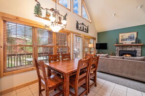 Relax in this spacious living room with a dining area, comfortable sofa, and stone fireplace.