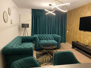 Ein modernes Wohnzimmer mit einem Ecksofa, einem runden Couchtisch und einem flachbildfernseher an der Wand.