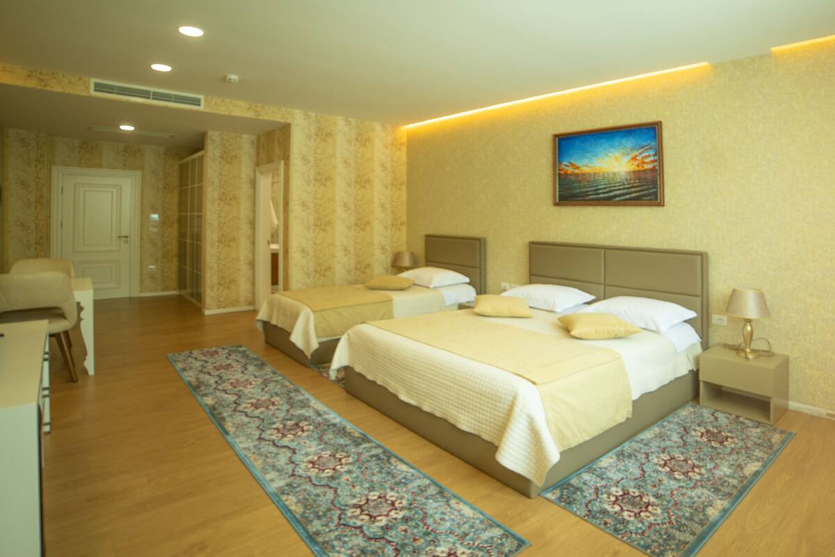 Une chambre d’hôtel avec deux lits, un coin salon et une salle de bain.