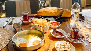 A table with breakfast items including eggs, bread, and French fries.