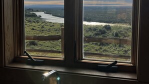 A window with a view of a river and landscape. - Yellowstone River Frontage! Beautiful log home on the river with 360  views! (Powell)