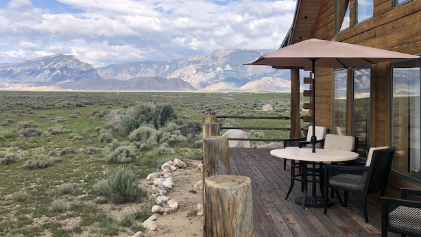 A wooden deck with outdoor seating and a mountain view. - Yellowstone River Frontage! Beautiful log home on the river with 360  views! (Powell)