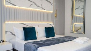 A modern bedroom with a large bed, a bedside table, and a wall-mounted mirror. - Last Minute Disney! Private Pool, Hot Tub, Game Room & Themed Bedrooms. Book Now! #90505 (Orlando)