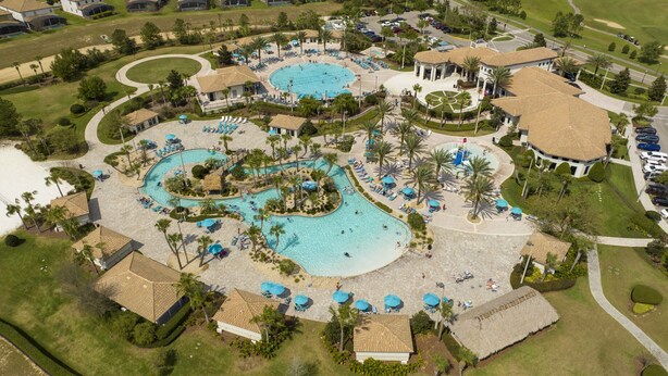Vista aérea de un resort con varias piscinas, palmeras y zonas de descanso.