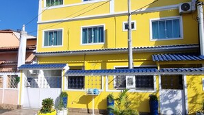 Un edificio amarillo de varios pisos con numerosas ventanas y balcones.