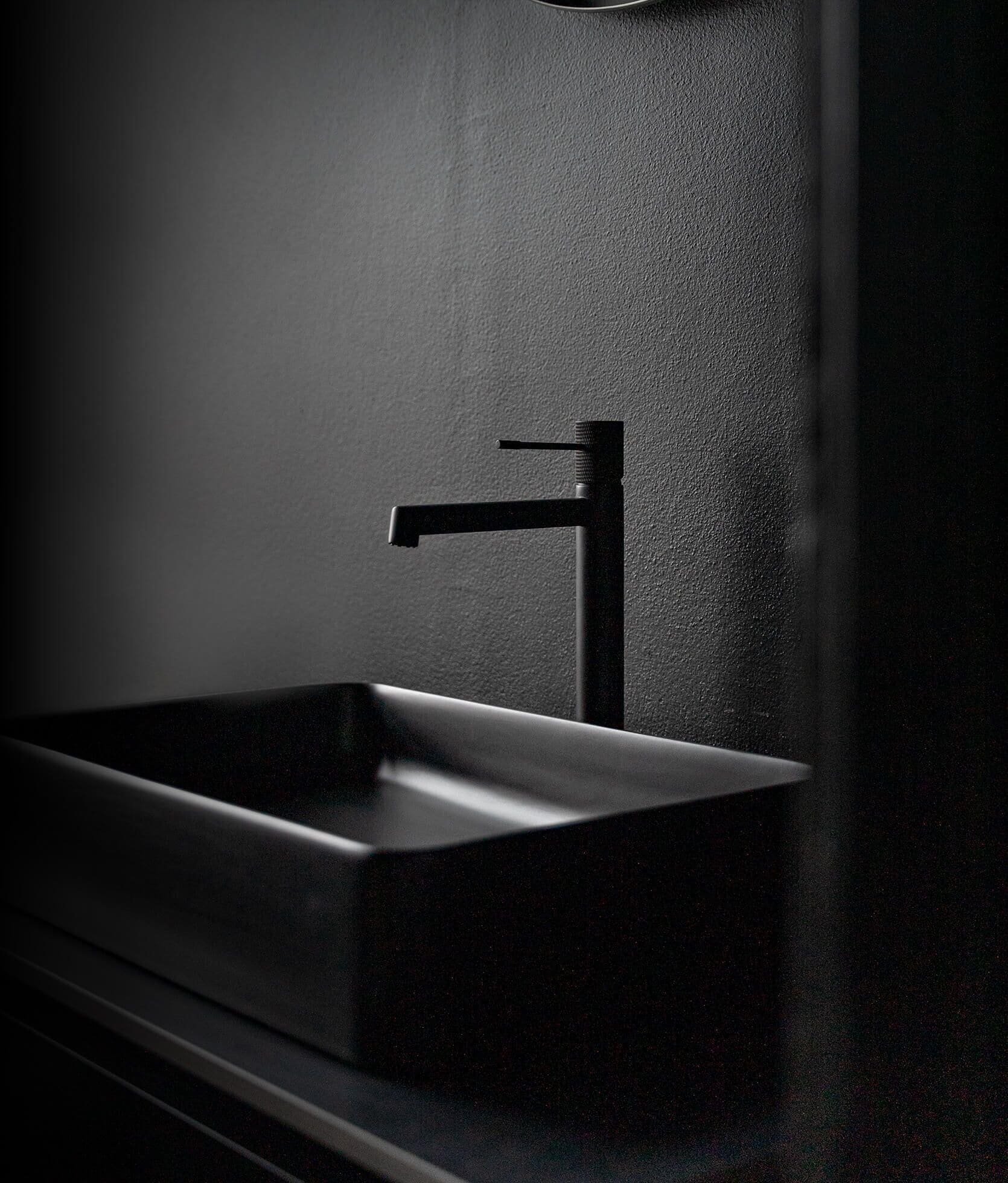A modern bathroom with a minimalist black sink and faucet.