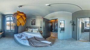A modern bedroom with a curved ceiling, a large bed, a unique hanging light fixture, and a view of the outdoors through a window. - hotel montagne (Åmmeberg)