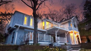 A two-story house with a balcony, a front porch, and a staircase leading to the entrance.
