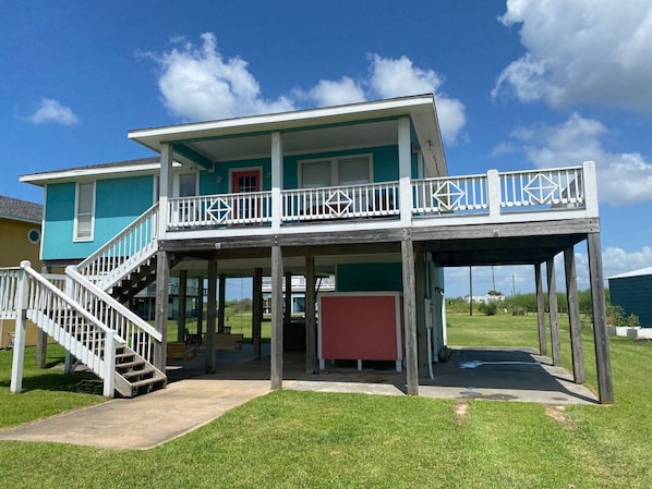 A two-story house with a balcony, a staircase, and a covered porch area.
