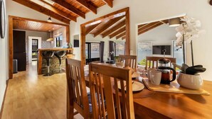 A dining area with wooden furniture, a coffee maker, and a view of the outdoors.